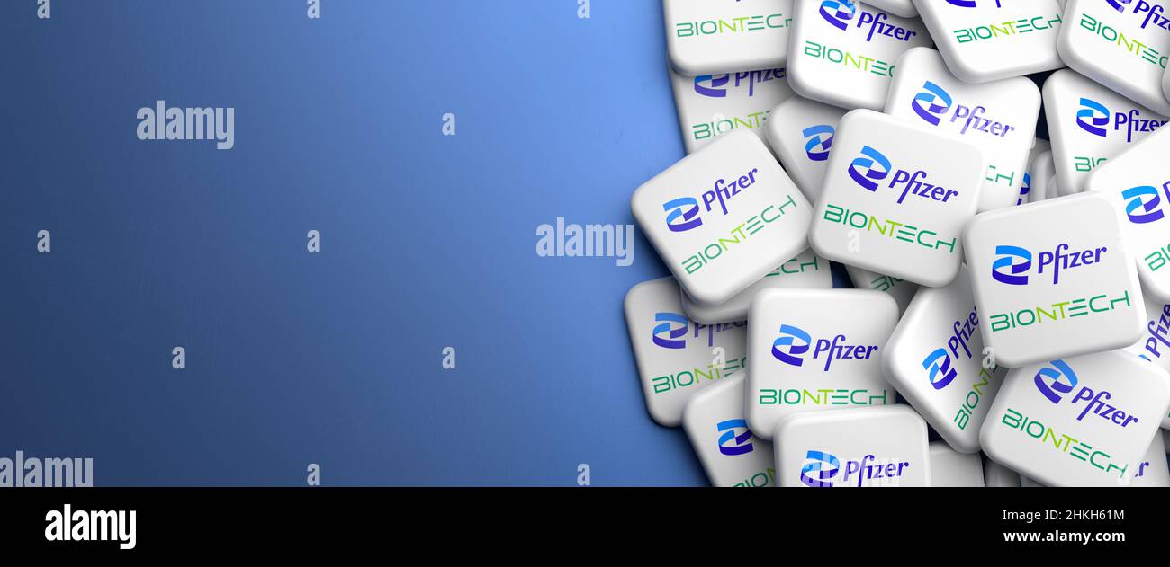 Logos des sociétés pharmaceutiques Pfizer et BioNTech qui développent et commercialisent conjointement le vaccin corona Comirnaty sur un tas sur une table. Banque D'Images