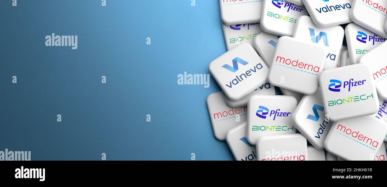 Logos des principales sociétés qui vendent les vaccins Covid-19 BioNTech/Pfizer, Moderna et Valneva sur un tas sur une table.Copier l'espace.Format de bannière Web. Banque D'Images