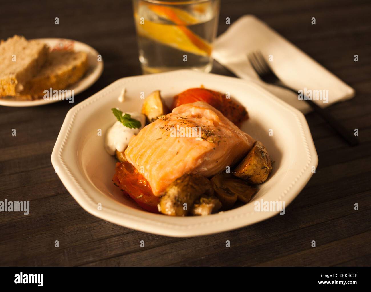 faire mijoter une tranche de saumon avec du spinon de tomate et de la sauce à la noix de coco dans un bol blanc Banque D'Images