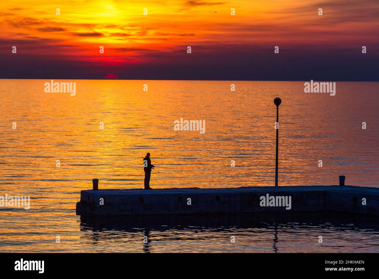 Coucher de soleil avec silhouette de pêcheur à la mer.Le lagon vert de Porec, dans la péninsule d'Istrie, en Croatie, en Europe. Banque D'Images