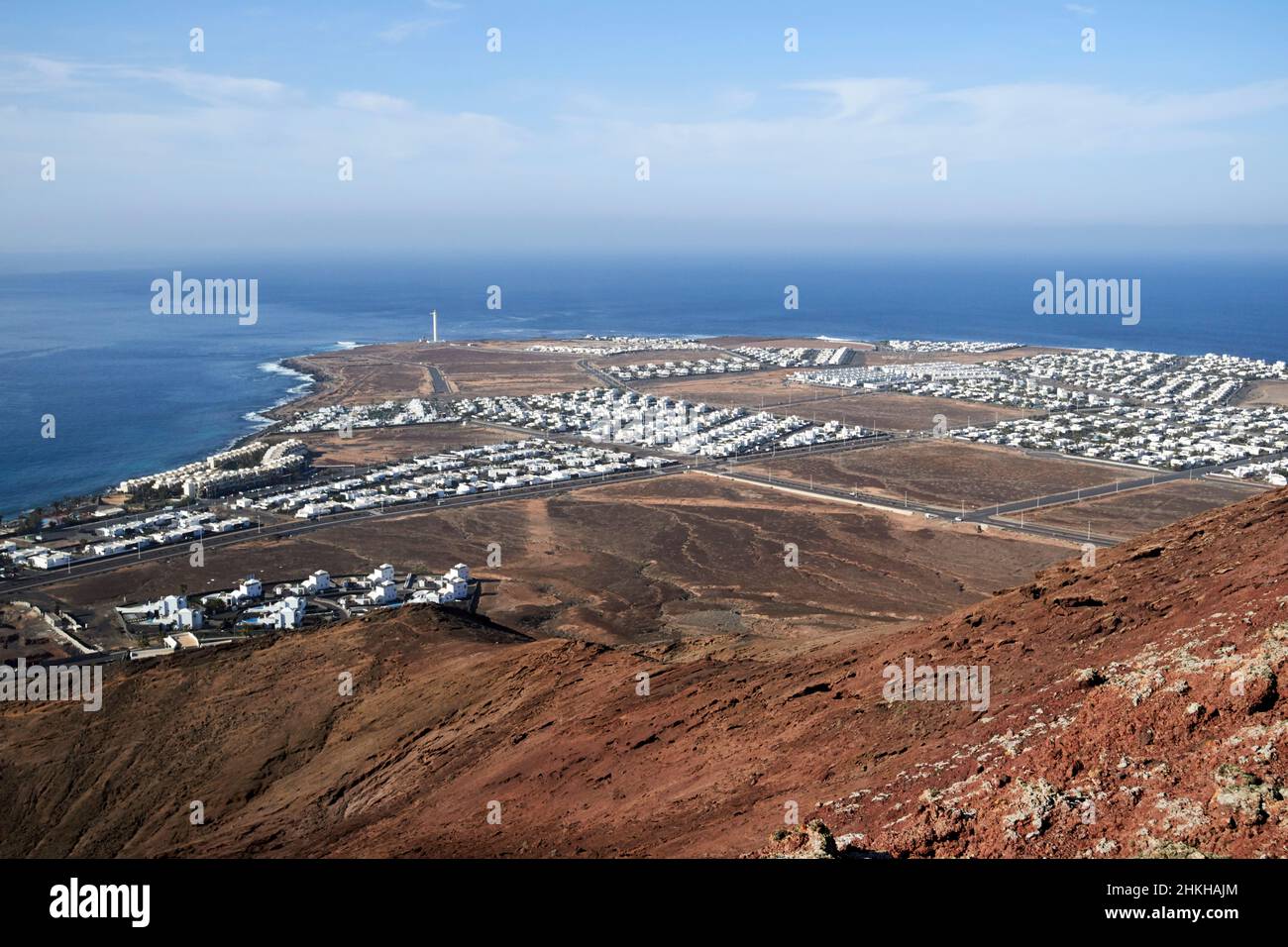 Vue sur faro et punta pechiguera depuis le sommet du volcan rouge montana roja éteint près de playa blanca Lanzarote Iles Canaries Espagne Banque D'Images