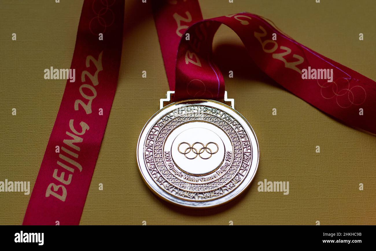 14 janvier 2022, Beijing, Chine.Médaille d'or des XXIV Jeux Olympiques d'hiver sur fond jaune. Banque D'Images