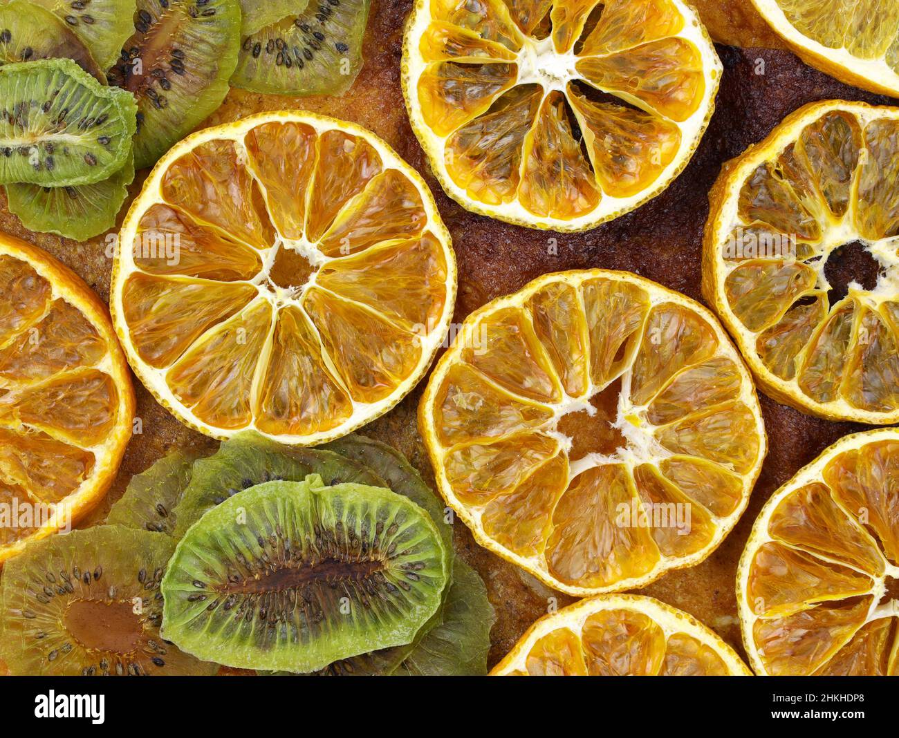 Rondelles d'oranges séchées et kiwi vue de dessus arrière-plan.Agrumes séchés faits maison.Gros plan sur les chips de fruits.Délicieux en-cas végétariens. Banque D'Images