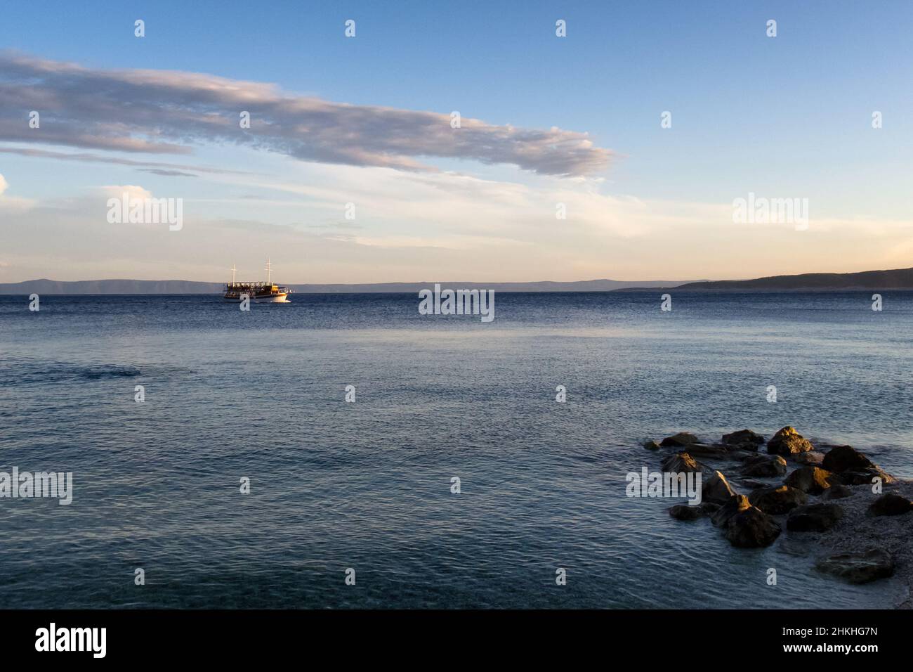 Un petit bateau de croisière sur la mer Adriatique dans la soirée près de la station balnéaire de Baska Voda sur la Riviera de Makarska en Croatie, en Europe. Banque D'Images