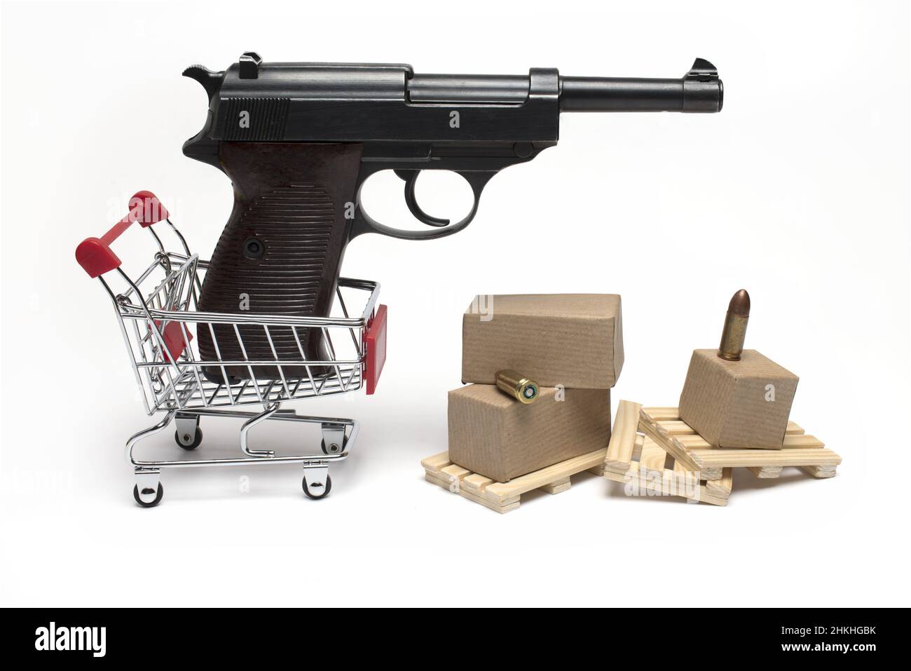 Gros plan du pistolet semi-automatique noir dans un petit chariot avec des palettes en bois et des munitions à côté de lui sur fond blanc concept de commerce de pistolet et Banque D'Images