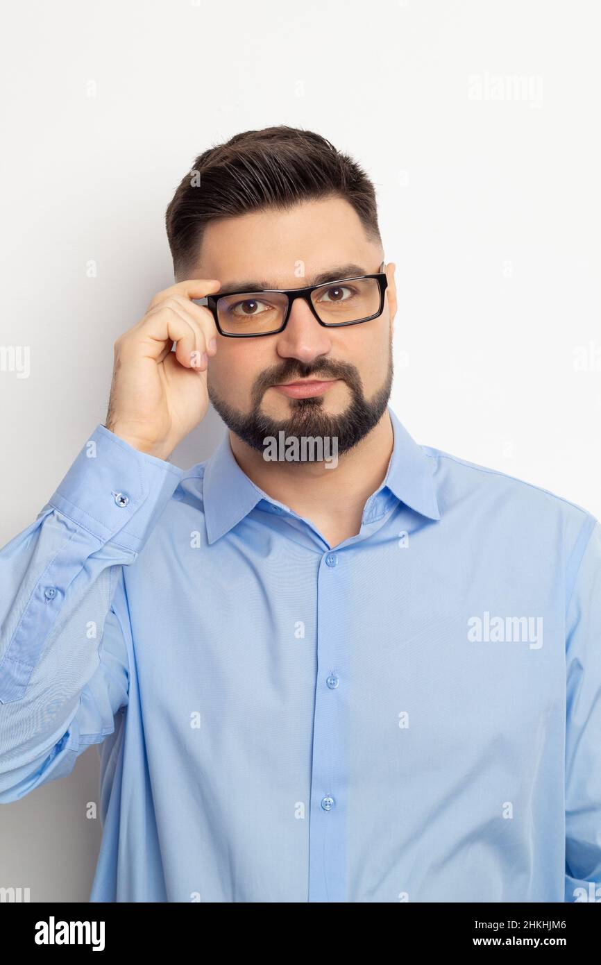 Portrait d'un homme d'affaires en lunettes regardant l'appareil photo sur un fond blanc. Banque D'Images