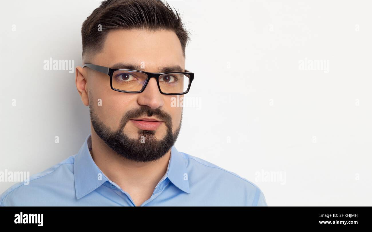 Portrait d'un beau homme d'affaires en lunettes avec une barbe sur fond blanc. Banque D'Images