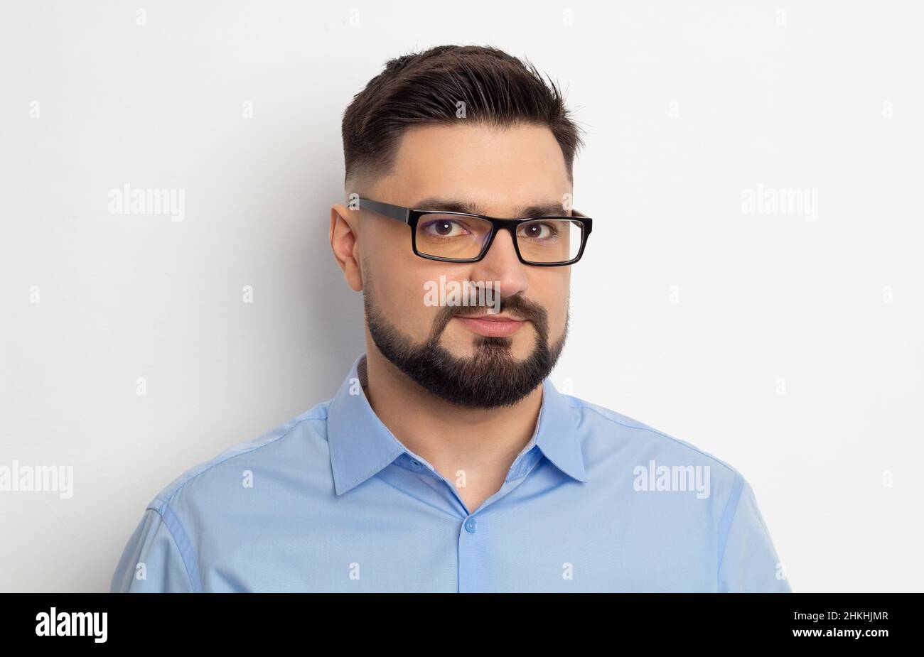 Portrait d'un beau homme d'affaires en lunettes avec une barbe sur fond blanc. Banque D'Images