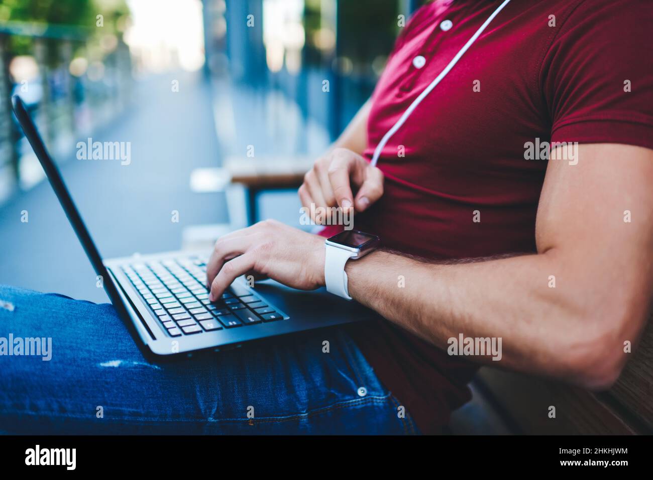 Homme utilisant un ordinateur portable assis sur un banc Banque D'Images