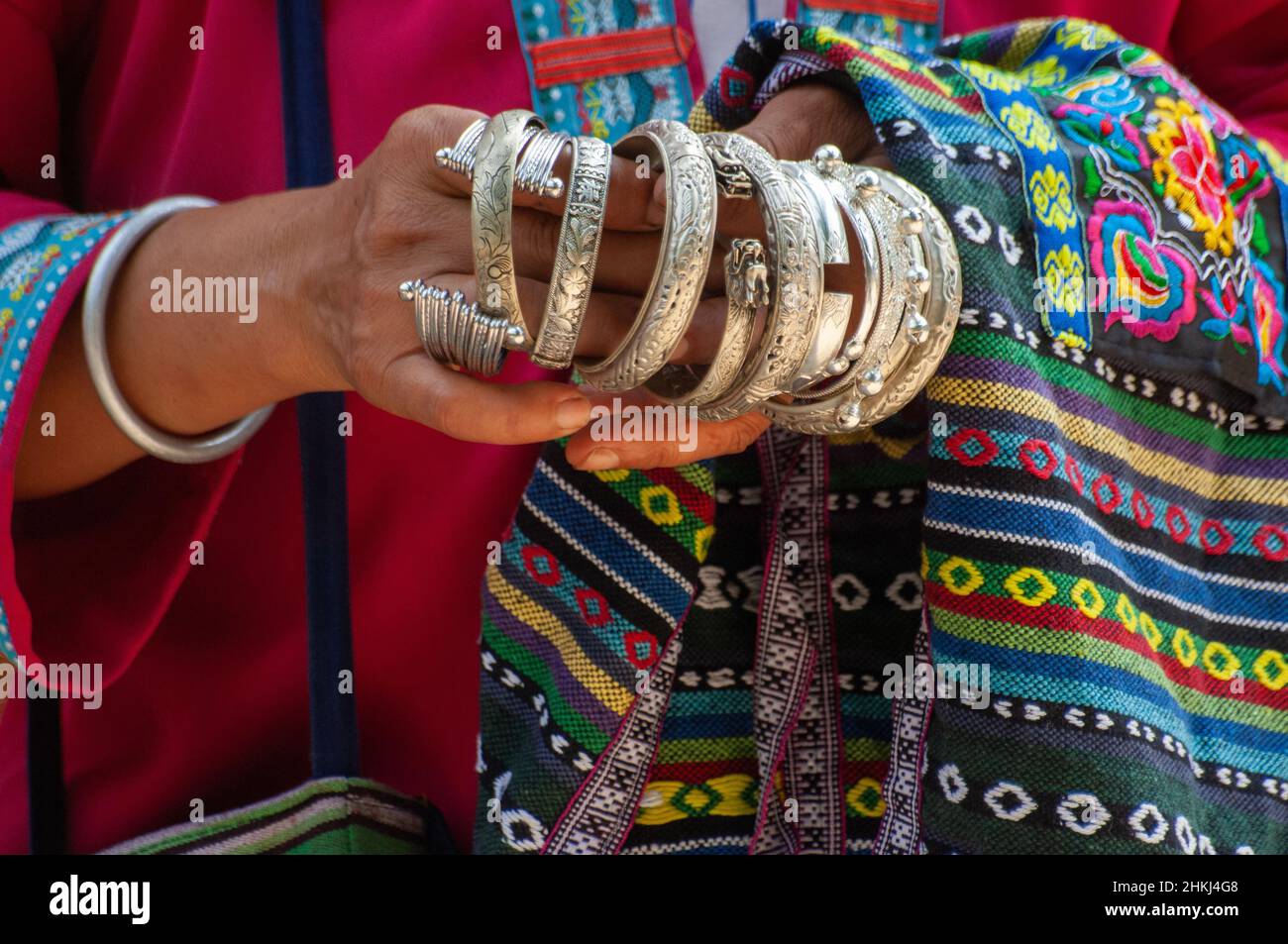Les mains de femme tribale vendant des bracelets en argent Banque D'Images