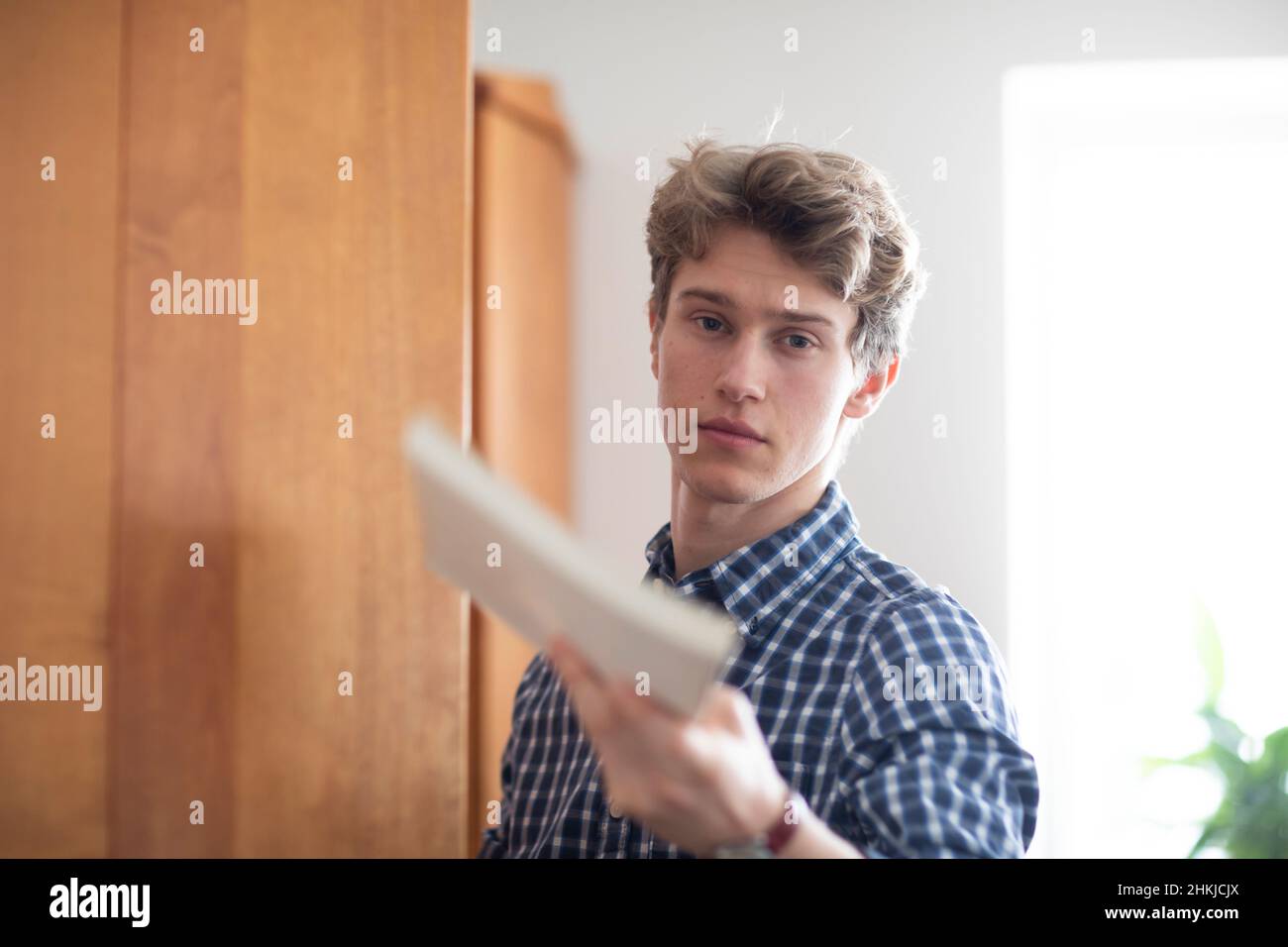étudiant recherchant un livre d'apprentissage à la maison Banque D'Images