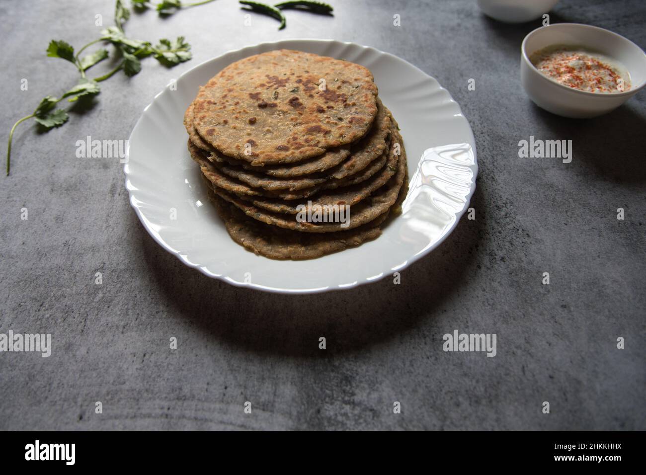 Plat de petit-déjeuner populaire aloo ka paratha ou pain plat farci de pomme de terre dans une assiette blanche. Gros plan. Banque D'Images