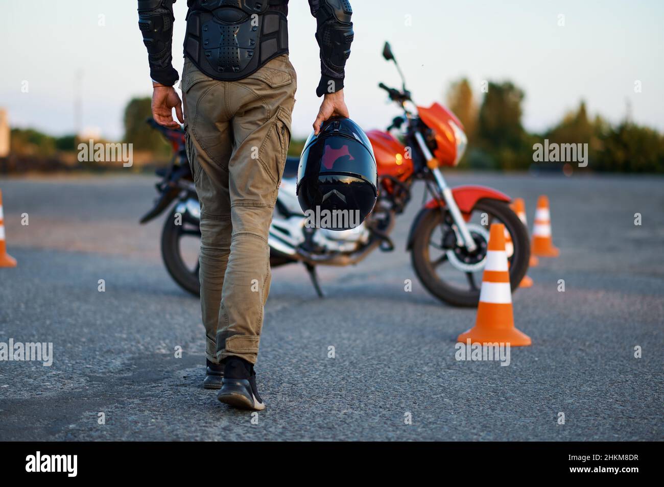 Un homme tient un casque, une école de moto Banque D'Images