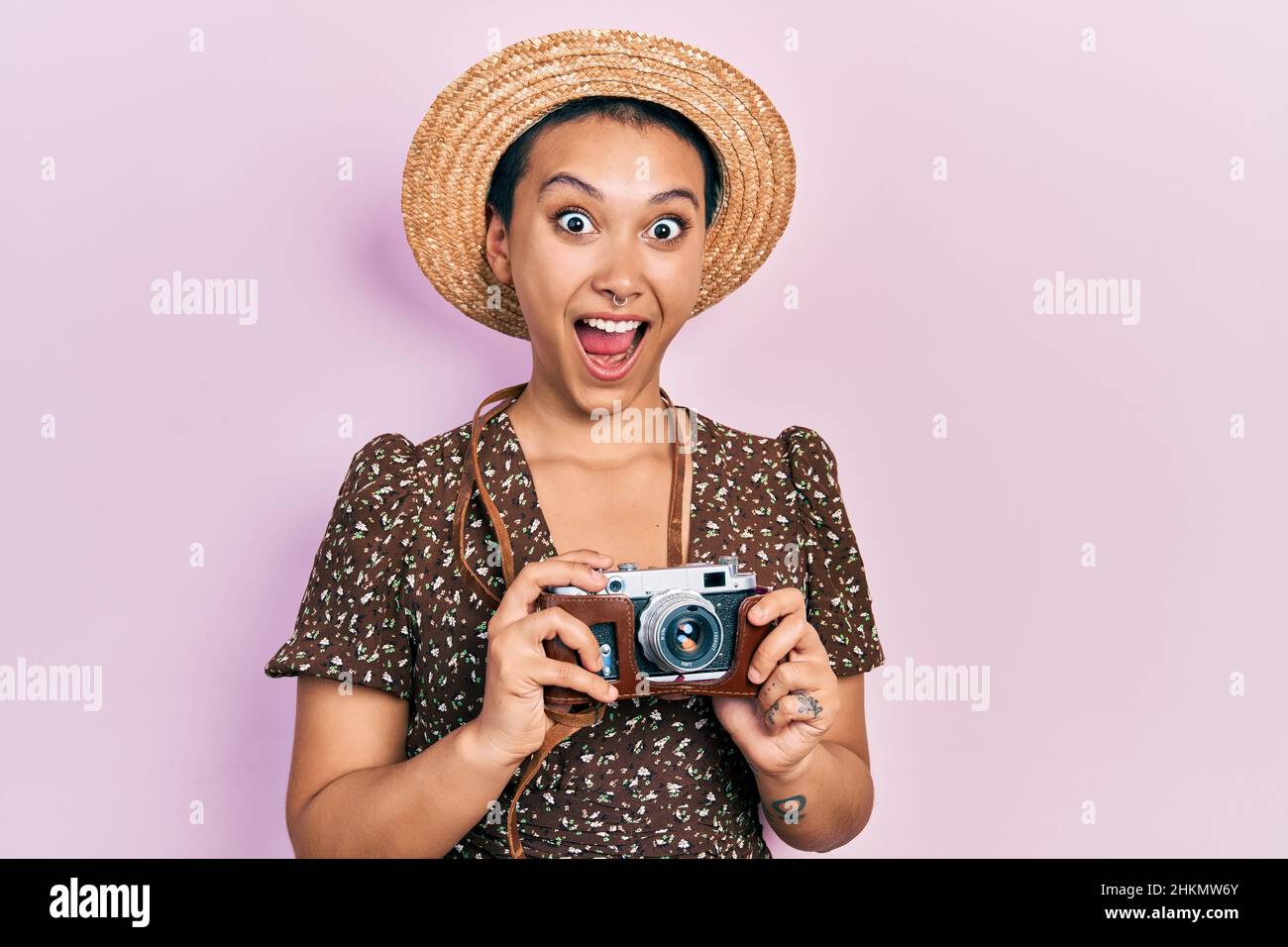 Belle femme hispanique avec cheveux courts portant chapeau d'été tenant  appareil photo vintage célébrant fou et stupéfié pour le succès avec les  yeux ouverts criant e Photo Stock - Alamy