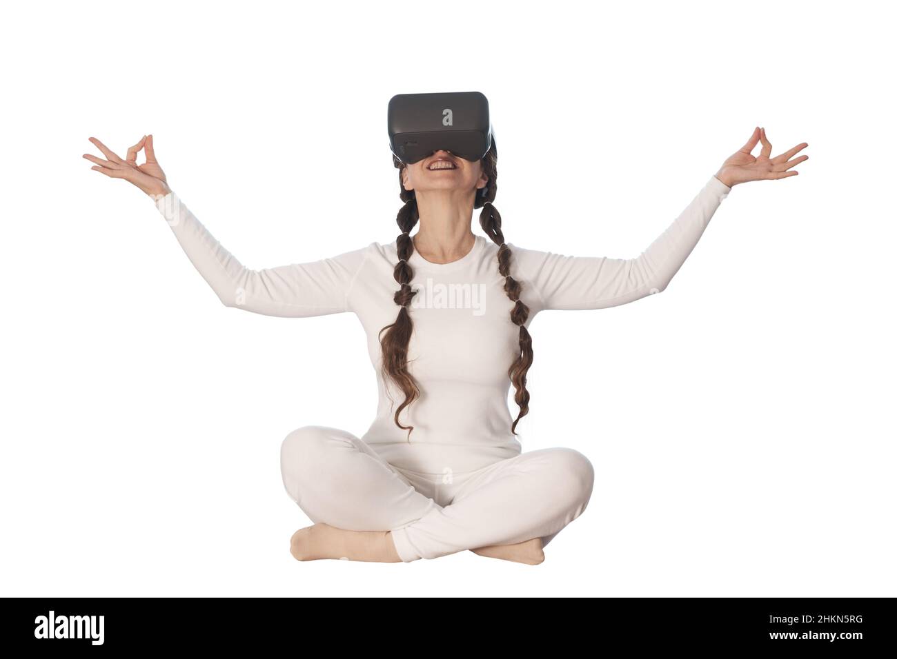 Une femme fait du yoga avec des lunettes de réalité virtuelle.Elle prend diverses poses de yoga et des sourires. Banque D'Images