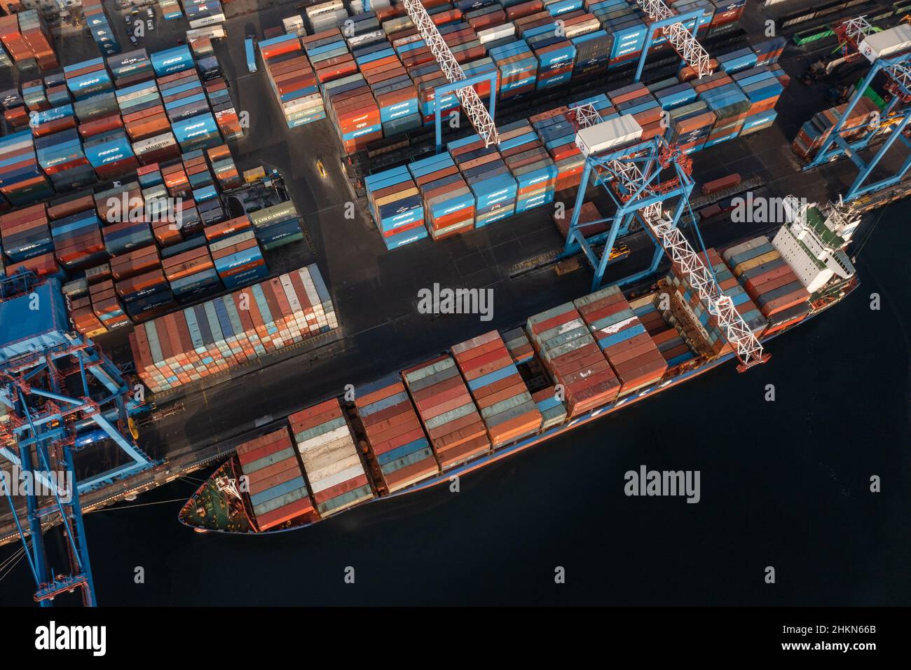 Vladivostok, Russie - 26 janvier 2022 : Vue de dessus du terminal des conteneurs du port maritime.En hiver, un bateau à conteneurs est en train de charger à l'embarcadère. Banque D'Images