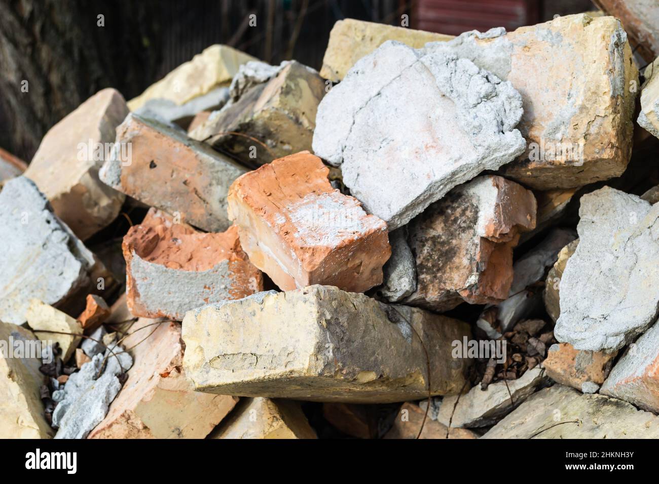 Un tas de vieilles briques utilisées avec des rayures et des fissures de l'ancien mur près de la parcelle. Banque D'Images