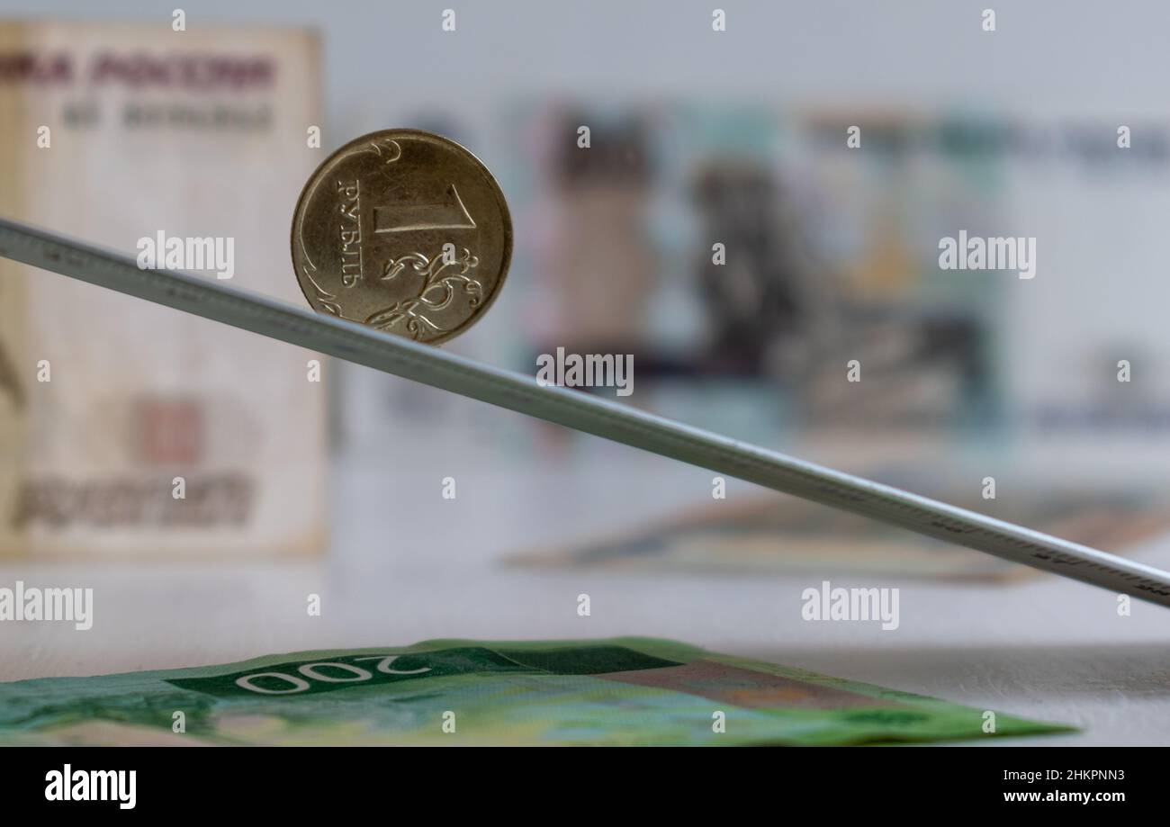 Une pièce de rouble sur fond plat incliné sur fond flou de billets de roubles russes Banque D'Images