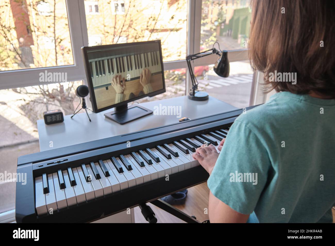 Garçon apprenant à jouer du piano dans l'apprentissage à distance via Internet Banque D'Images