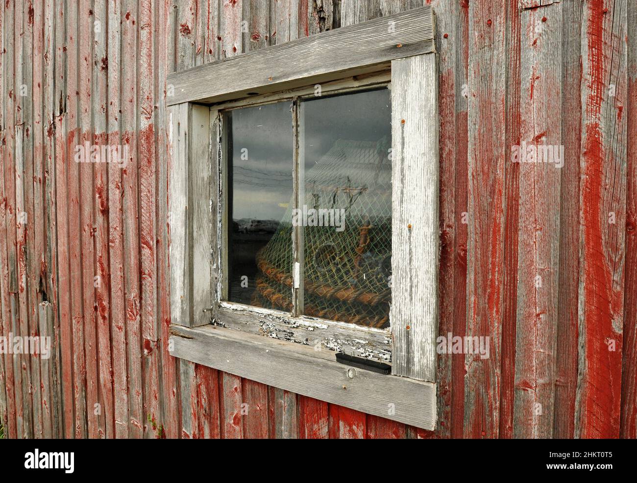 Une fenêtre abîmé entoure du matériel de pêche entreposé dans un hangar du village de Victoria, sur la rive sud de l'Île-du-Prince-Édouard. Banque D'Images