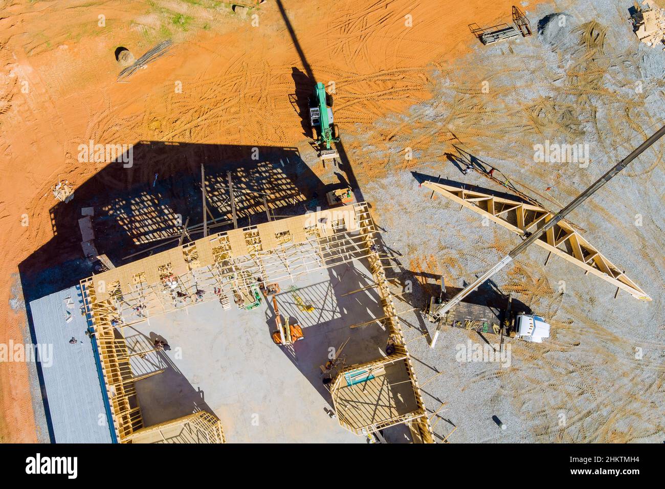 La grue tient un bois de charpente de toit pour le toit de la maison Banque D'Images