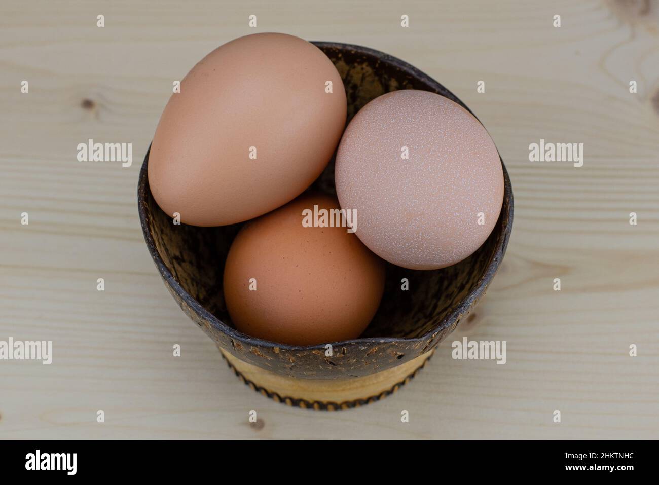 Cuisson des œufs dans un bol de noix de coco.Ingrédient protéique pour un petit déjeuner sain.Préparation des omelettes.Coquilles d'œufs cassées sur la table.Le transparent, jaune Banque D'Images