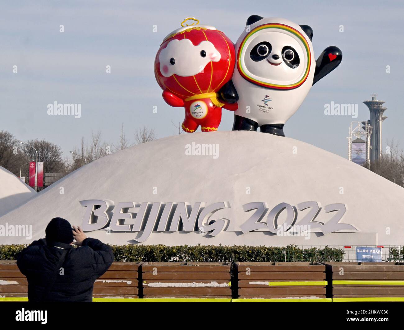 Pékin, Chine.06th févr. 2022.Jeux olympiques, fonctionnalité.Un homme prend une photo des mascottes olympiques Panda Bing Dwen (r/Jeux olympiques) et Shuey Rhon Rhon (Jeux paralympiques d'hiver de 2022).La tour Oympia peut être vue en arrière-plan.Credit: Peter Kneffel/dpa/Alay Live News Banque D'Images