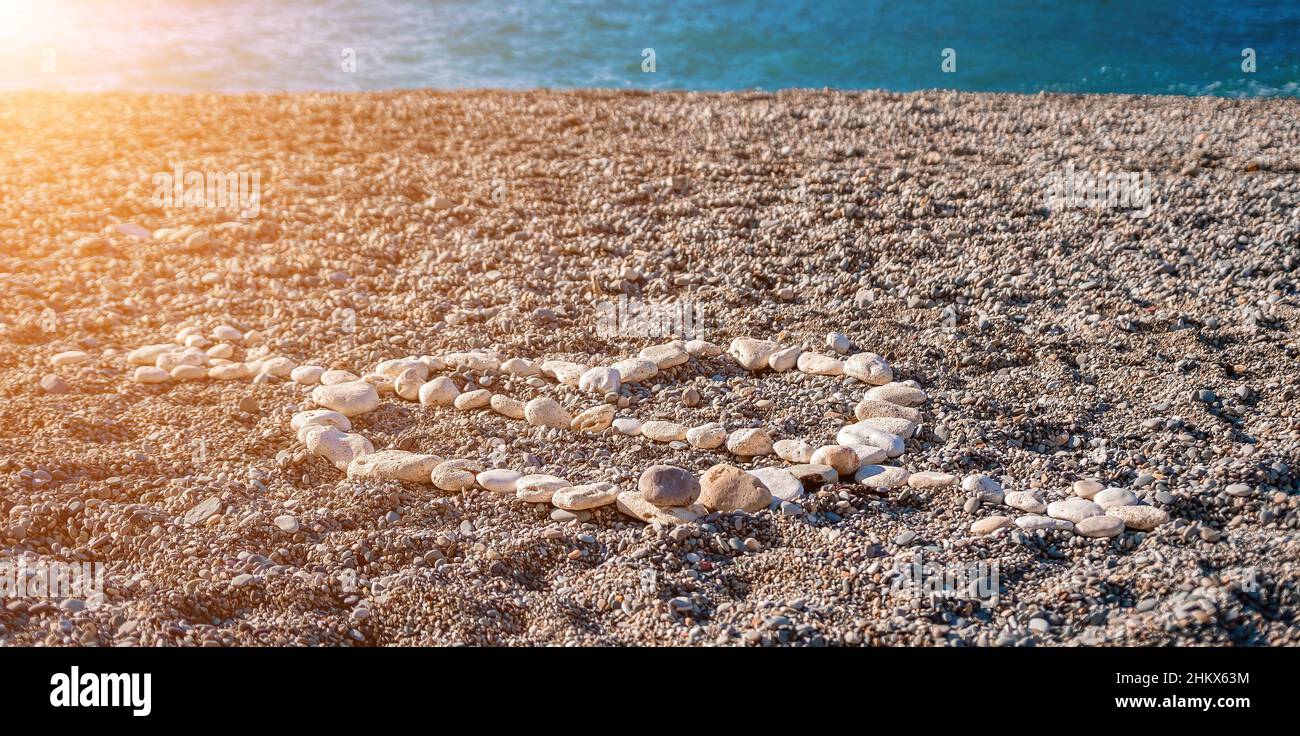 J'aime la forme de coeur sur le sable fait de galets blancs, symbole de l'amour sur la plage avec fond de mer.Saint-Valentin symbole de l'amour de la forme du coeur, l'amour Banque D'Images