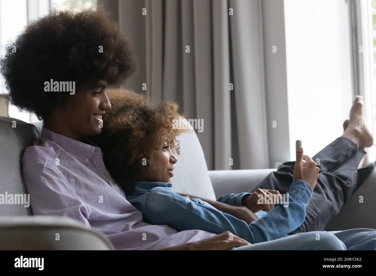 Heureux datant Noir adolescent couple dans l'amour à l'aide de smartphone Banque D'Images