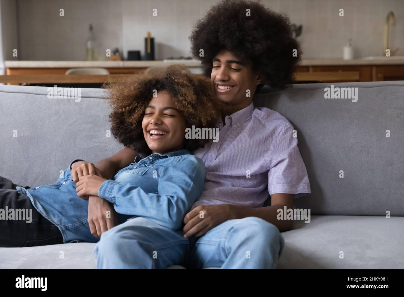 Joyeux couple adolescent de rencontres dans l'amour se détendre sur le canapé à la maison Banque D'Images