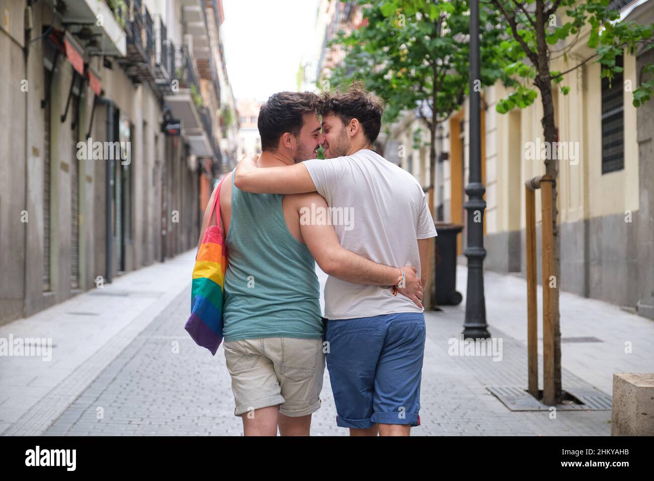 Couple gay sur le point de s'embrasser en marchant et en embrassant dans la rue en arrière. Banque D'Images