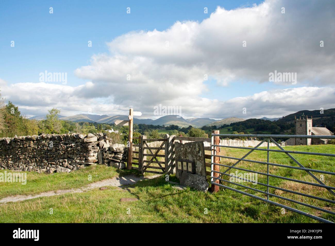 Panneau et porte menant à l'église St Michael et All Angels Hawkshead Lake District Cumbria Angleterre Banque D'Images