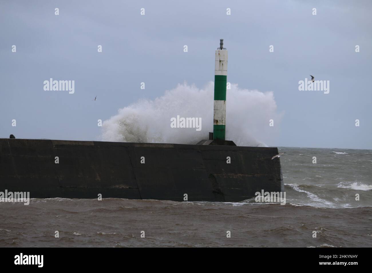 Aberystwyth pays de Galles Royaume-Uni météo Febuary 6th 2022 .De grandes vagues se brisent dans et au-dessus de la lumière du port et de la promenade lors d'une froide journée d'hiver sur la côte ouest de la grande-bretagne, de forts vents avec un refroidissement mordant entraînent les vagues géantes à marée haute, ce qui peut endommager les structures et les biens.Crédit : mike davies/Alamy Live News Banque D'Images