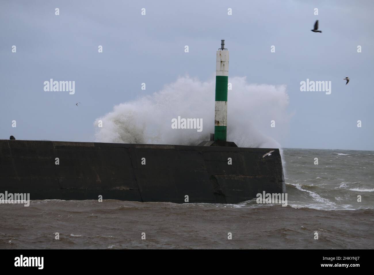 Aberystwyth pays de Galles Royaume-Uni météo Febuary 6th 2022 .De grandes vagues se brisent dans et au-dessus de la lumière du port et de la promenade lors d'une froide journée d'hiver sur la côte ouest de la grande-bretagne, de forts vents avec un refroidissement mordant entraînent les vagues géantes à marée haute, ce qui peut endommager les structures et les biens.Crédit : mike davies/Alamy Live News Banque D'Images