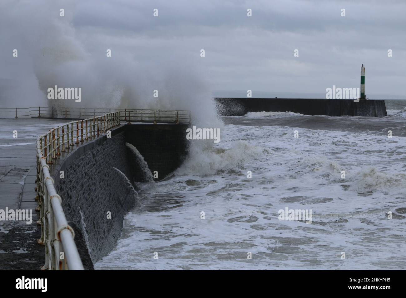 Aberystwyth pays de Galles Royaume-Uni météo Febuary 6th 2022 .De grandes vagues se brisent dans et au-dessus de la lumière du port et de la promenade lors d'une froide journée d'hiver sur la côte ouest de la grande-bretagne, de forts vents avec un refroidissement mordant entraînent les vagues géantes à marée haute, ce qui peut endommager les structures et les biens.Crédit : mike davies/Alamy Live News Banque D'Images