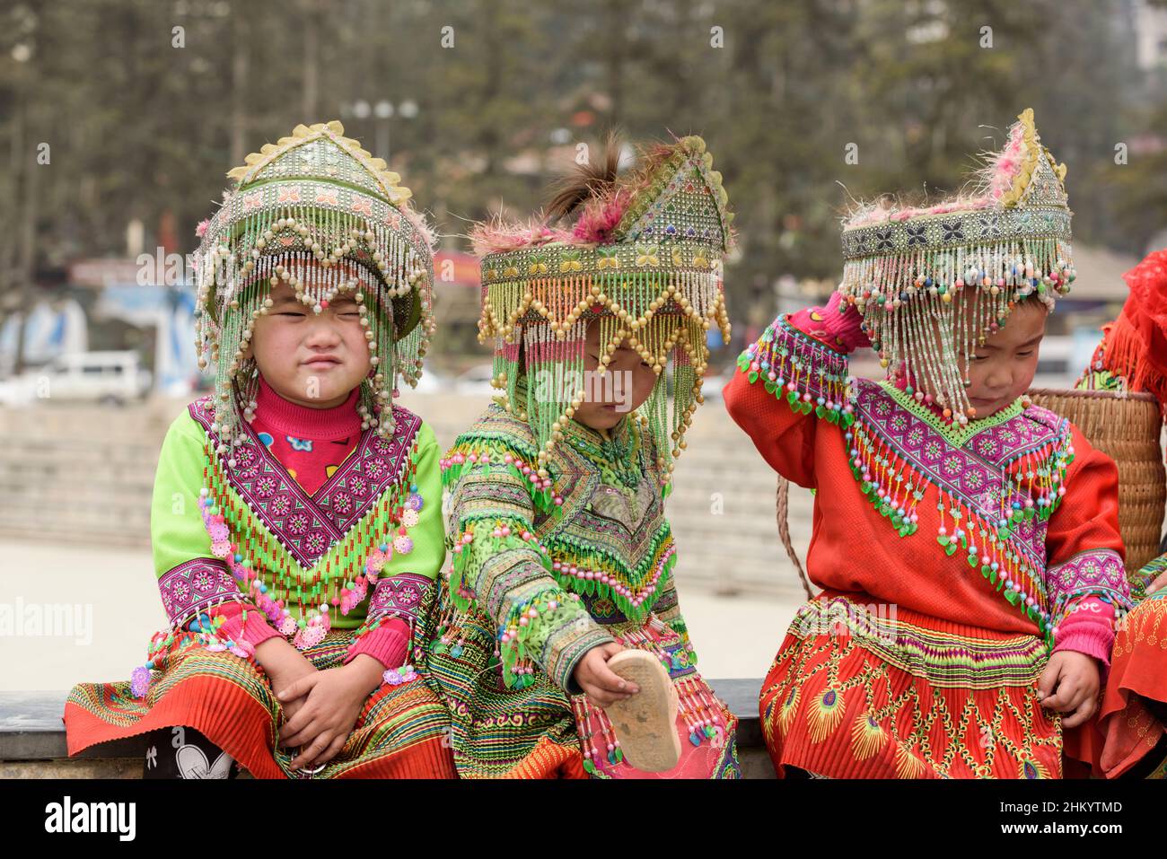 Les jeunes filles, portant des vêtements traditionnels de la tribu Hmong, attendent de poser pour des photos de touristes sur la place de la ville, Sapa (sa Pa), Lao Cai, Vietnam Banque D'Images