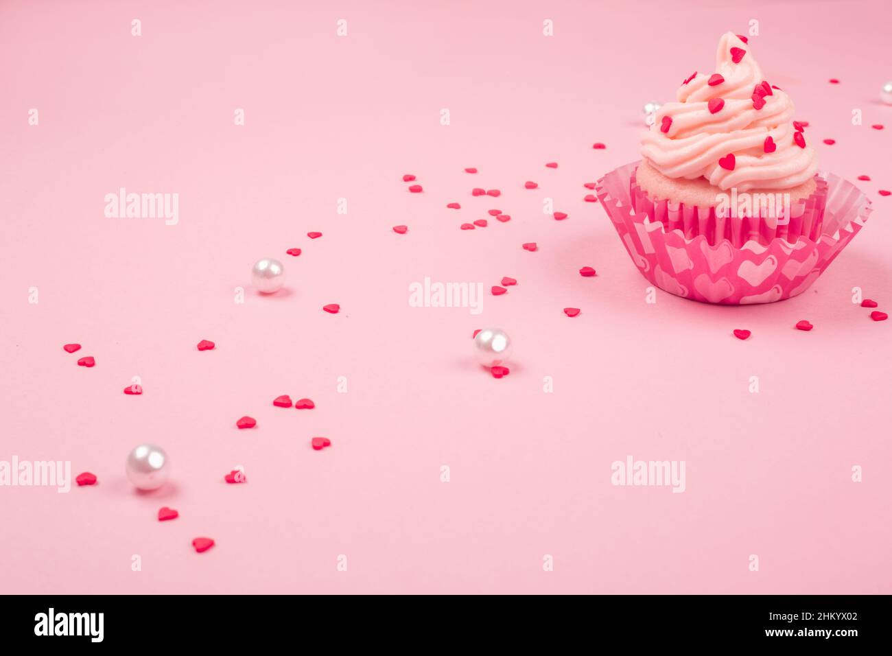 Amour saint valentin décoration cupcake à la crème et coeurs sur fond rose avec copie espace pour le texte Banque D'Images