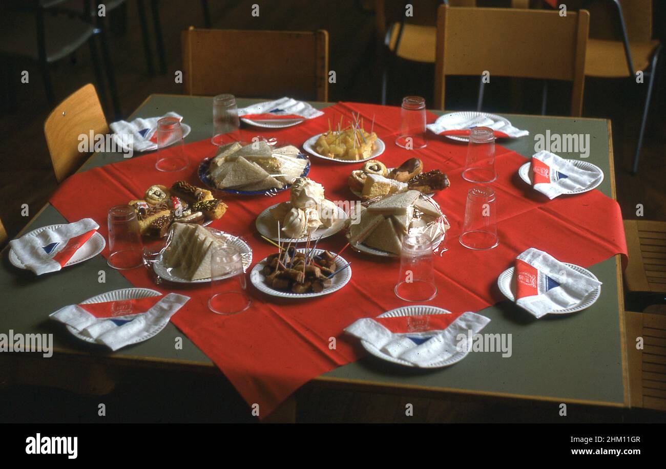 1977, historique, à l'école primaire, sandwichs, gâteaux et naplkins rouges et bleus sur des assiettes en papier, tous disposés sur une table avec un nappe rouge, prêt pour les enfants à s'asseoir ensemble pour célébrer le Jubilé d'argent de sa Majesté, la reine Elizabeth II, Angleterre, Royaume-Uni. Banque D'Images