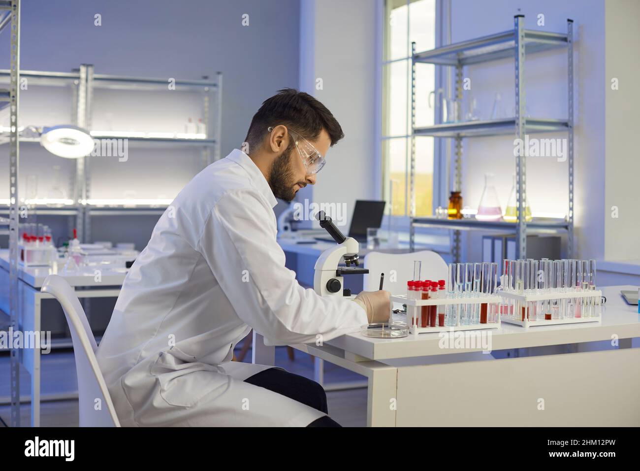 Un assistant de laboratoire de sexe masculin effectue des recherches en laboratoire Banque D'Images