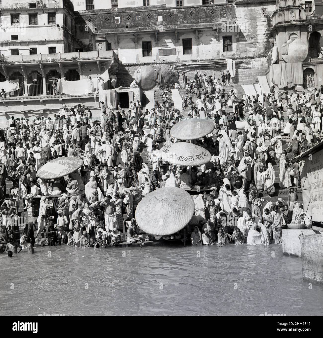 1950s, historique, Hindous réunis sur les rives abruptes du Gange, Benares (Varanasi), Inde, dans le cadre d'un pèlerinage religieux dans la ville ancienne, une des plus anciennes villes sans cesse habitées dans le monde.Les eaux du Gange sont considérées comme saintes dans la religion hindoue et sont un lieu de culte et de deuil pendant le pèlerinage. Banque D'Images