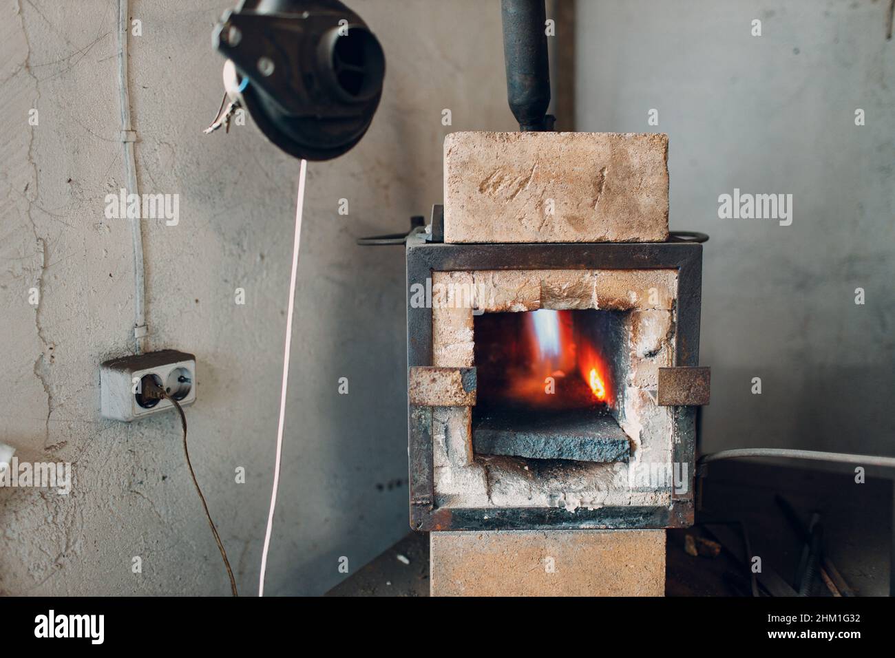 Forgeron four avec flamme chaude.Smith chauffage de fer morceau d'acier dans le feu de forge rouge-chaud. Banque D'Images