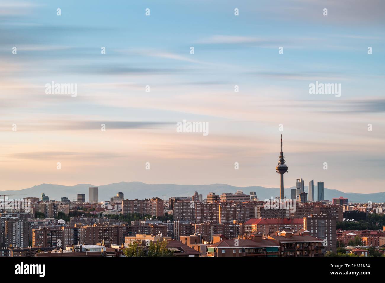 Horizon de Madrid au crépuscule comme vu de Cerro del Tio Pio, avec la tour de télévision et les gratte-ciels le long de Castellana pour être reconnu.Exposition longue. Banque D'Images