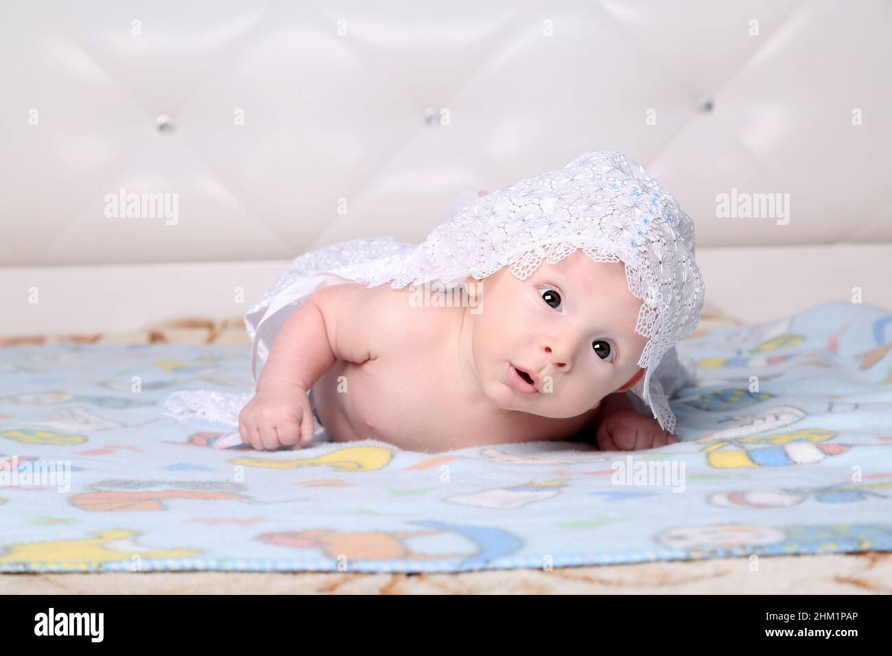 Le nouveau-né regarde dans l'appareil photo tout en étant allongé sur le ventre Banque D'Images