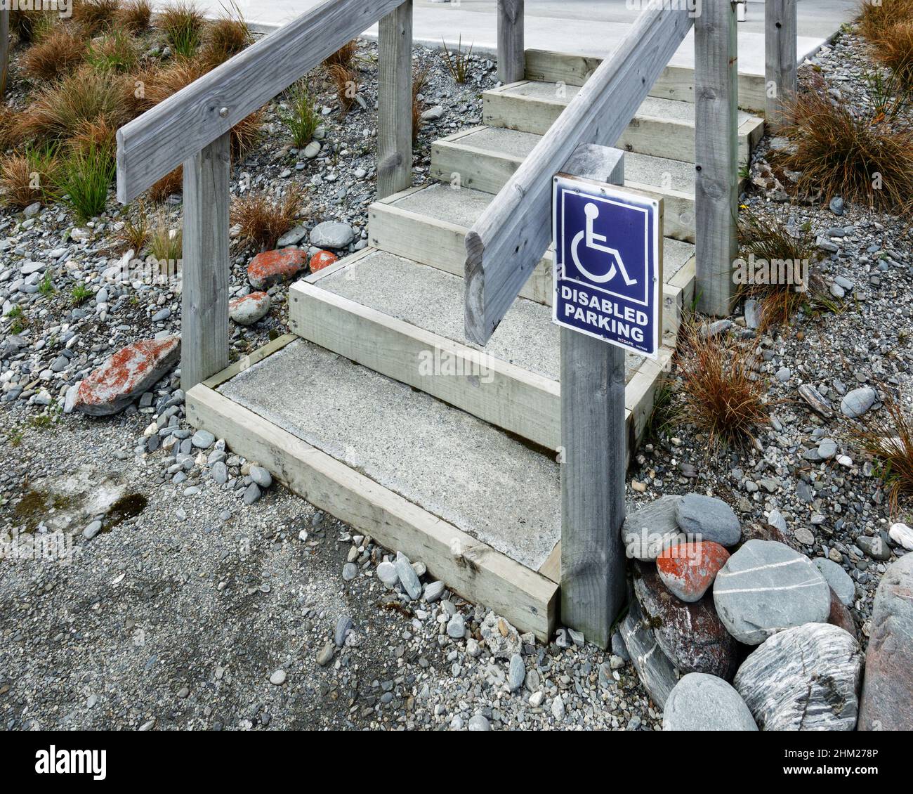 Parking handicapés, panneau pour fauteuil roulant à côté des escaliers menant aux toilettes. Banque D'Images
