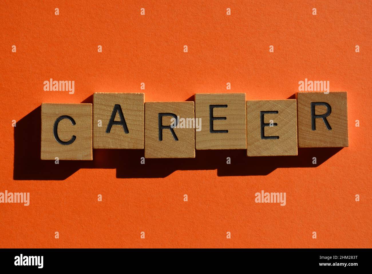 Carrière, mot en lettres de l'alphabet de bois isolées sur fond orange Banque D'Images