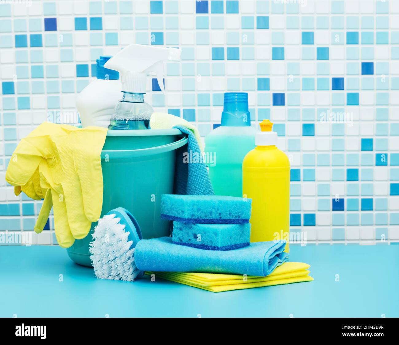 Nettoyants et détergents en seau, accessoires pour le nettoyage de diverses surfaces et pièces fond bleu Banque D'Images