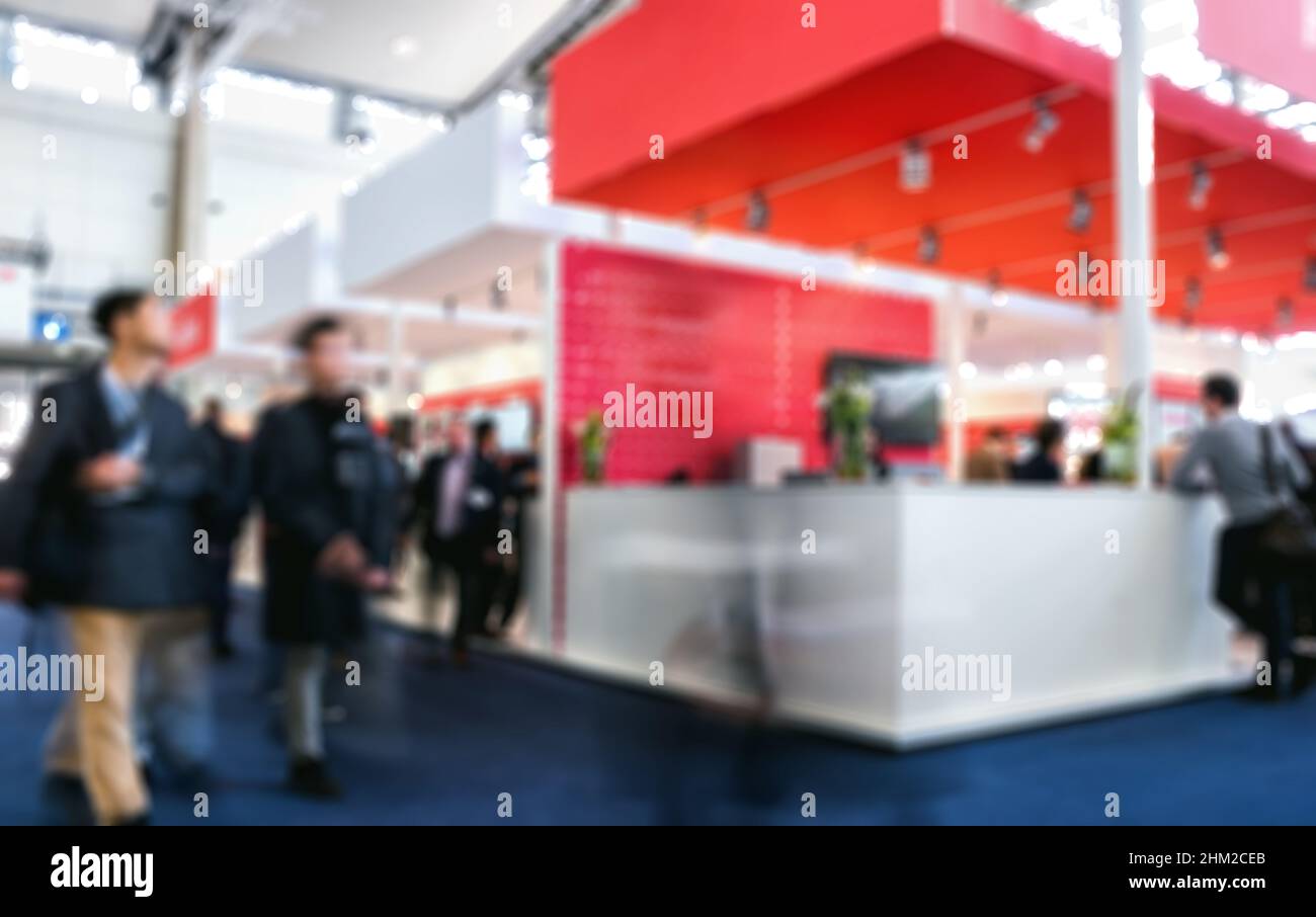 Les gens d'affaires qui marchent sur le stand du salon professionnel ont intentionnellement un arrière-plan flou Banque D'Images