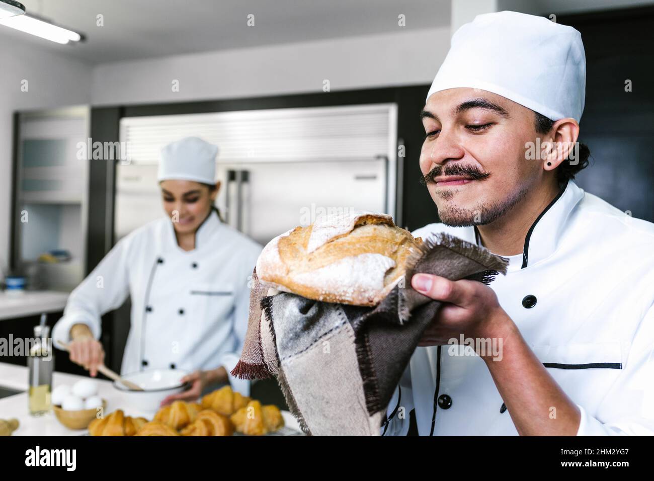 Un jeune latino boulanger et cuire du pain au four dans la cuisine du Mexique en Amérique latine Banque D'Images