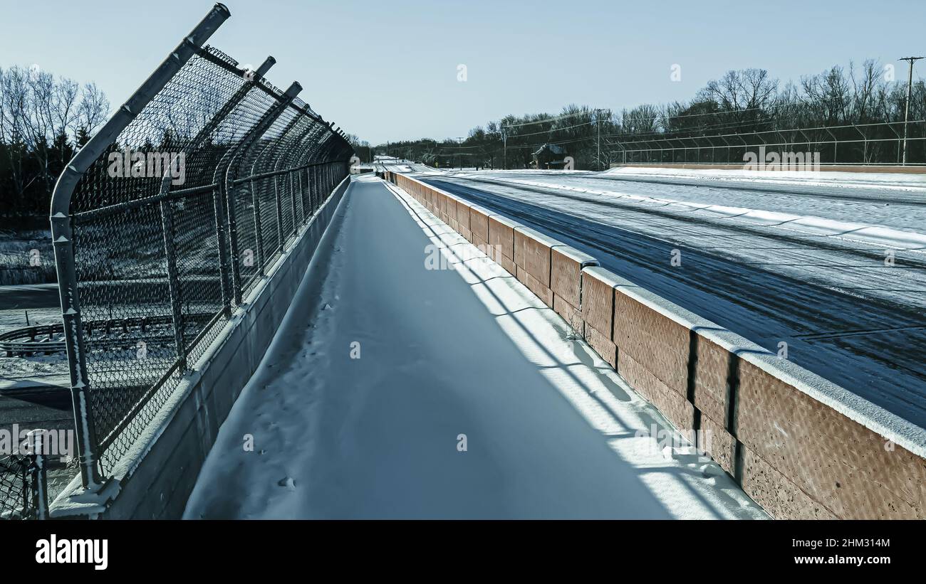 Passe-passage couvert de neige gelée.La route et l'autoroute sont couvertes de neige fraîche.Vue en perspective en traversant le trottoir au-dessus de l'autoroute. Banque D'Images