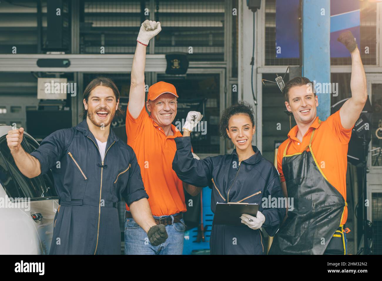 groupe de mécanicien personnel de service de voiture équipe travailleurs dans le garage sourire heureux de la main de risign Banque D'Images
